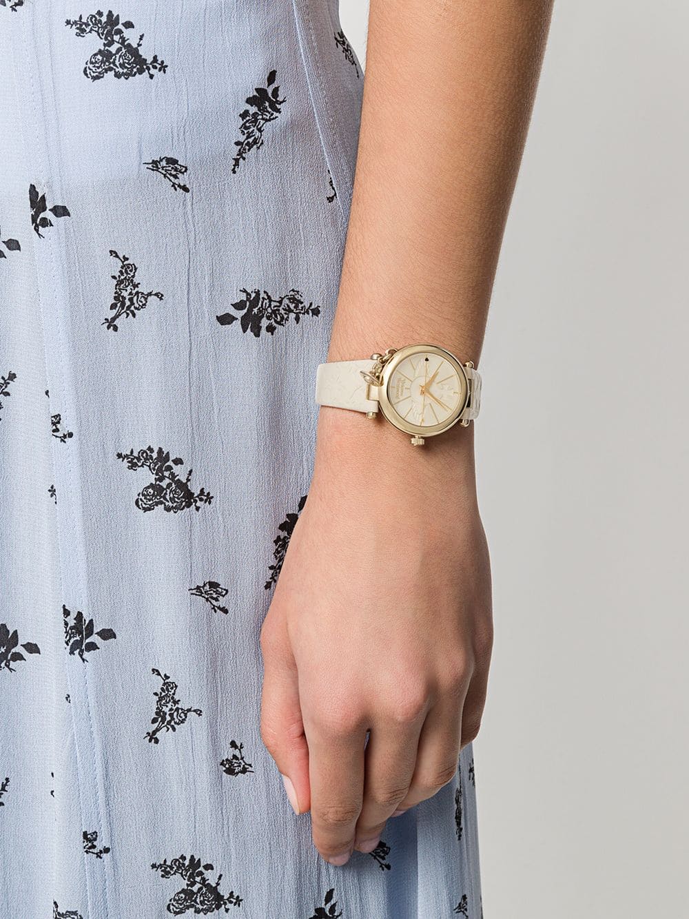 Vivienne Westwood Orb Pop Champagne Gold Ladies Watch vv006gdcm on a wrist with a light blue floral dress