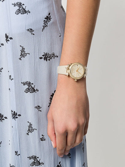 Vivienne Westwood Orb Pop Champagne Gold Ladies Watch vv006gdcm on a wrist with a light blue floral dress