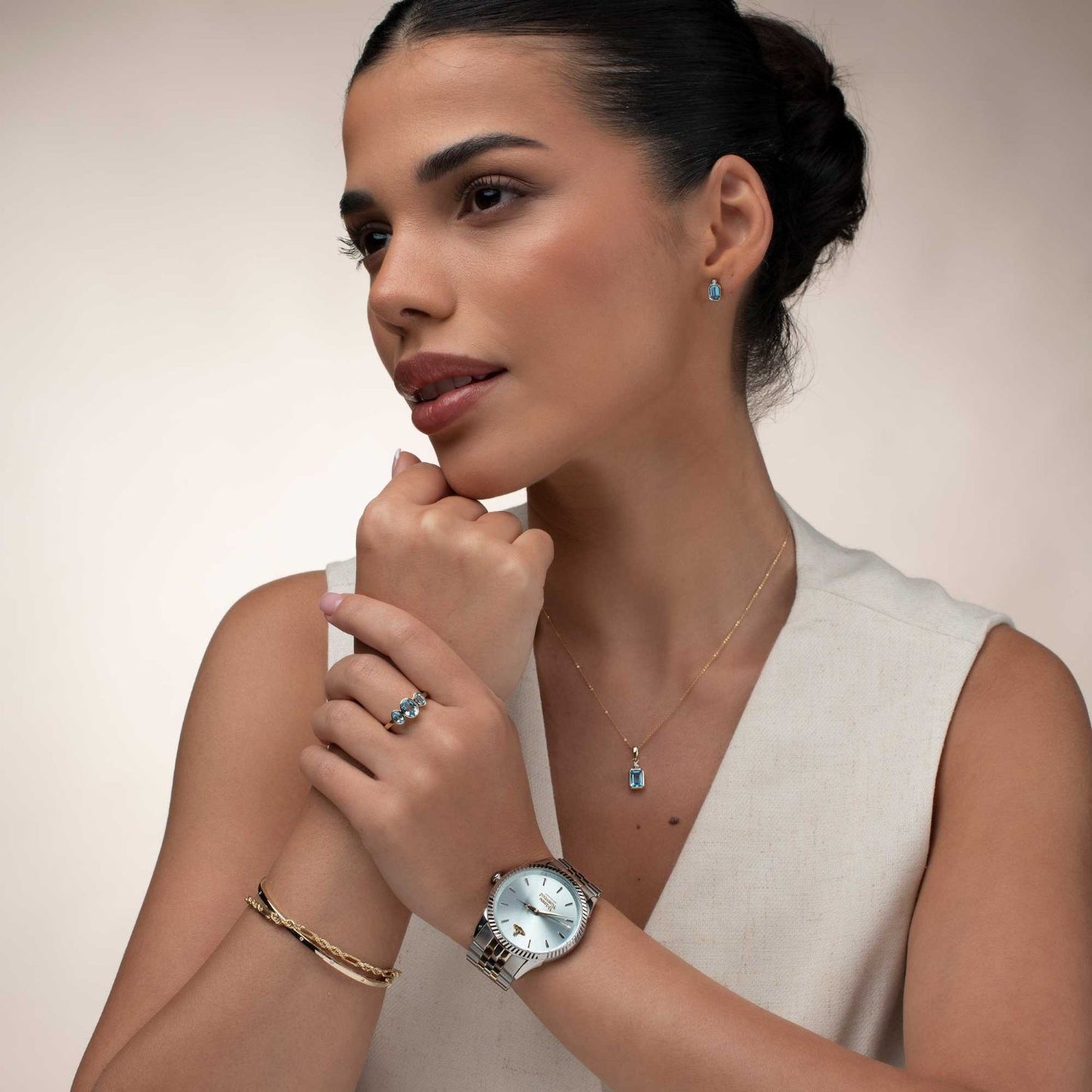 Woman wearing a Vivienne Westwood Seymour Blue Dial Silver Watch vv240lgrsg, bracelet, and ring with a neutral background