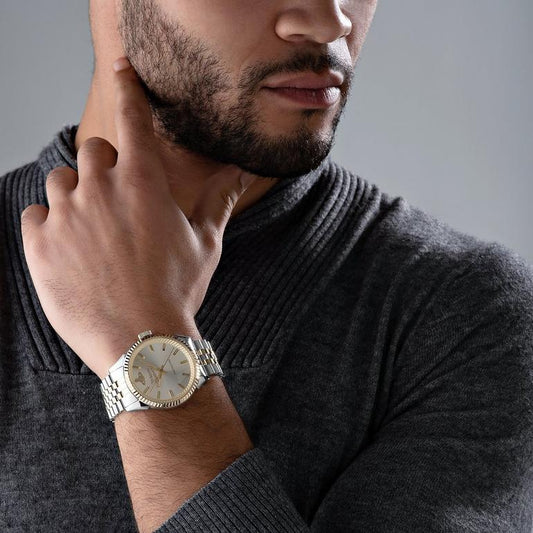 Man wearing a Vivienne Westwood Seymour Homme Champagne Dial Silver Watch VV242CMSG with a gray background