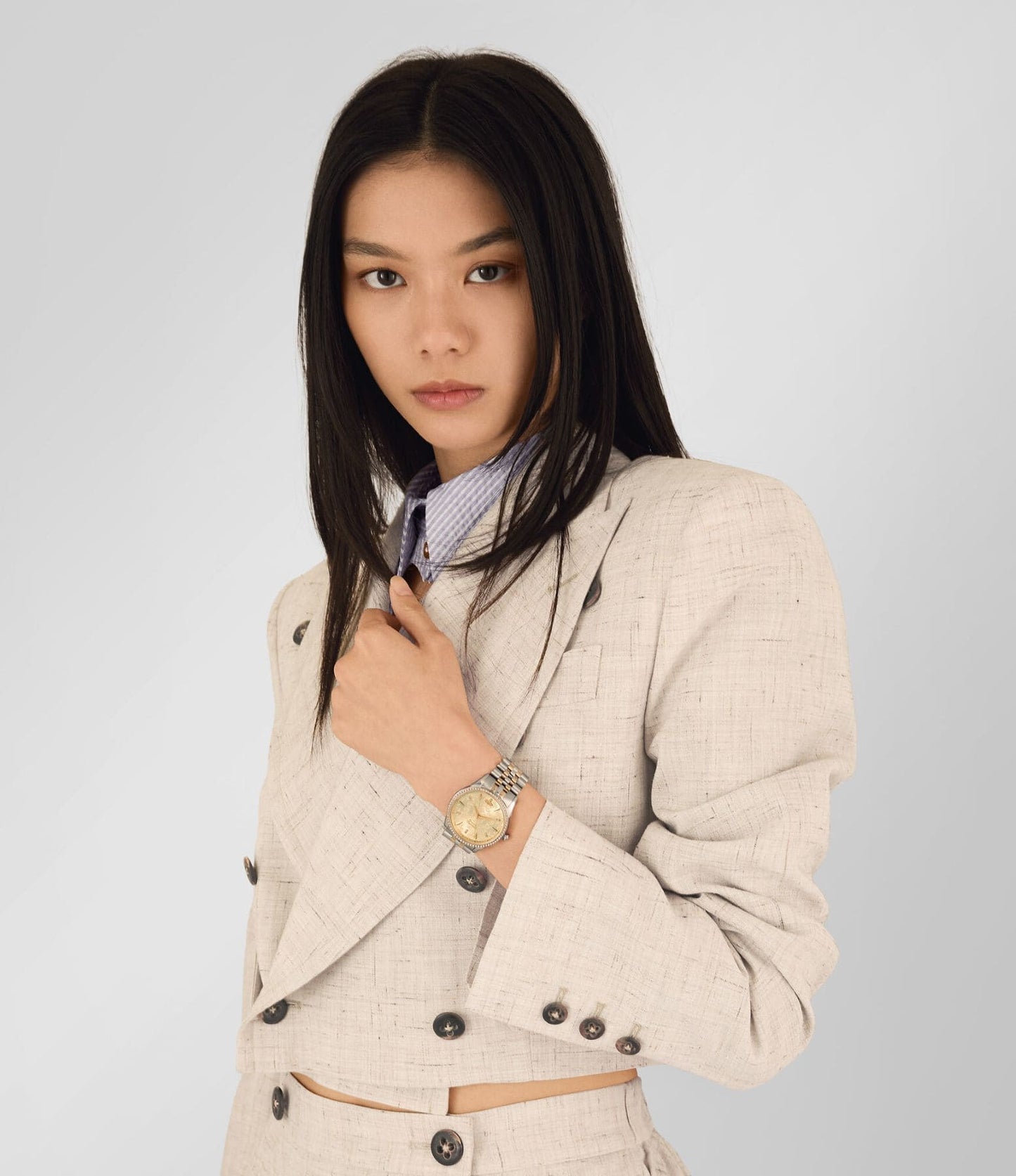 Woman wearing a beige blazer with a Vivienne Westwood Wallace Watch Gold Dial Silver Watch VV208CPSG in white background